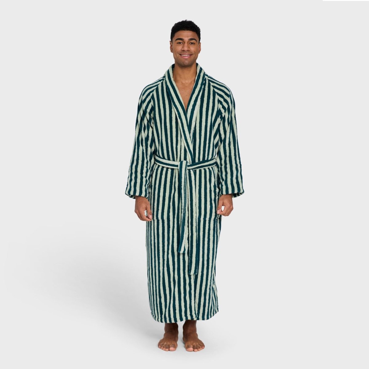 Soft sea foam and deep teal Naram bathrobe by Bongusta, showcasing plush fabric and cozy fit in a bathroom setting.