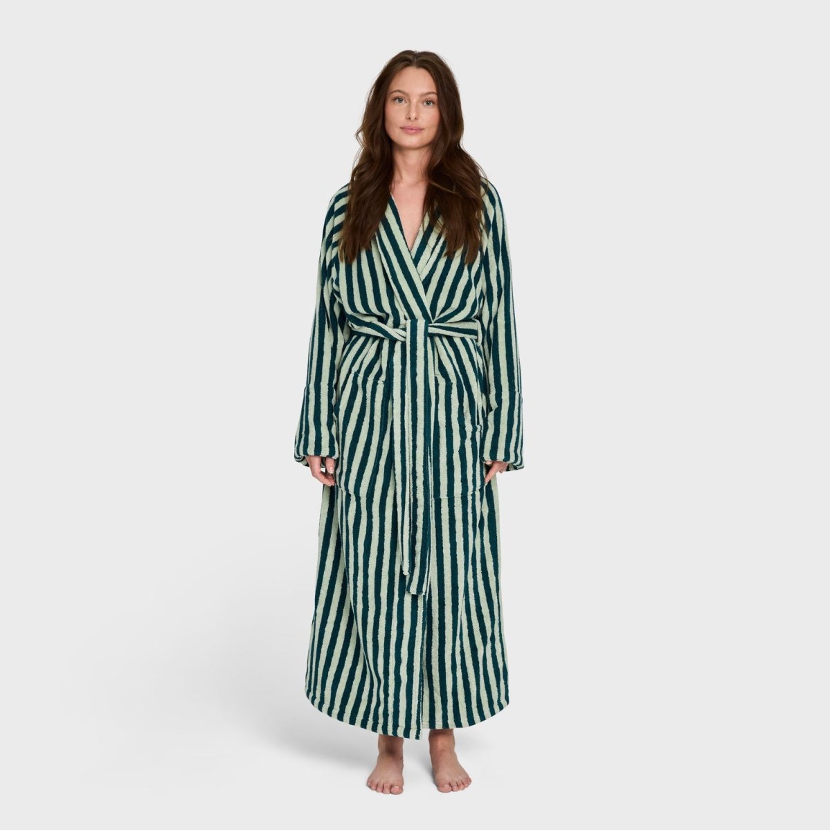 Soft sea foam and deep teal Bongusta Naram bathrobe displayed on a hanger, showcasing plush fabric and cozy design.