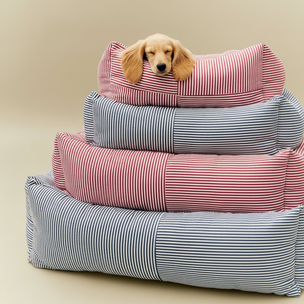 Stack of striped pet beds with a small dog peeking out from the top one.