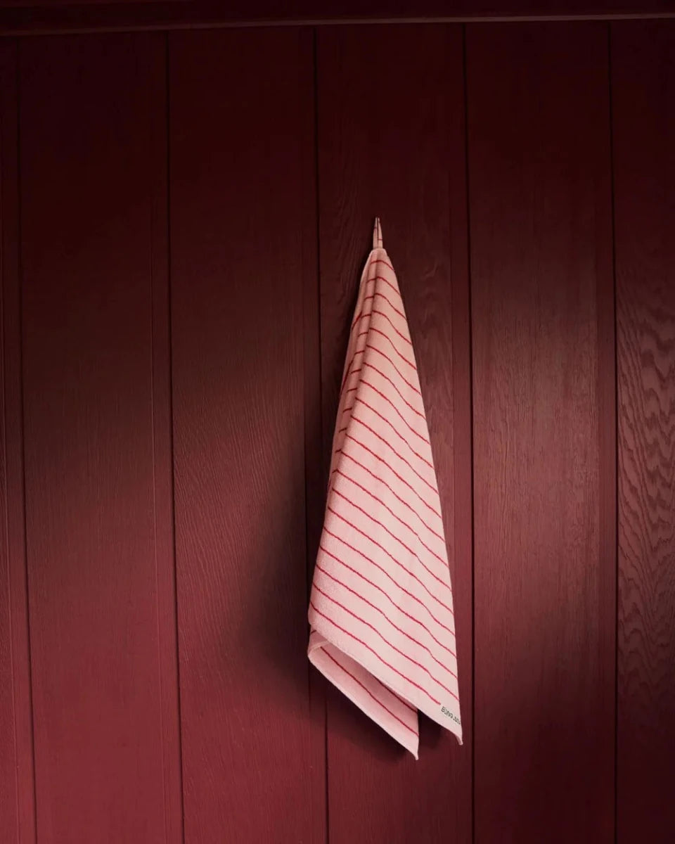 Bongusta Naram Bathroom Towel in Baby Pink and Ski Patrol colors, soft and plush for bathroom use, shown hanging on a towel rack.