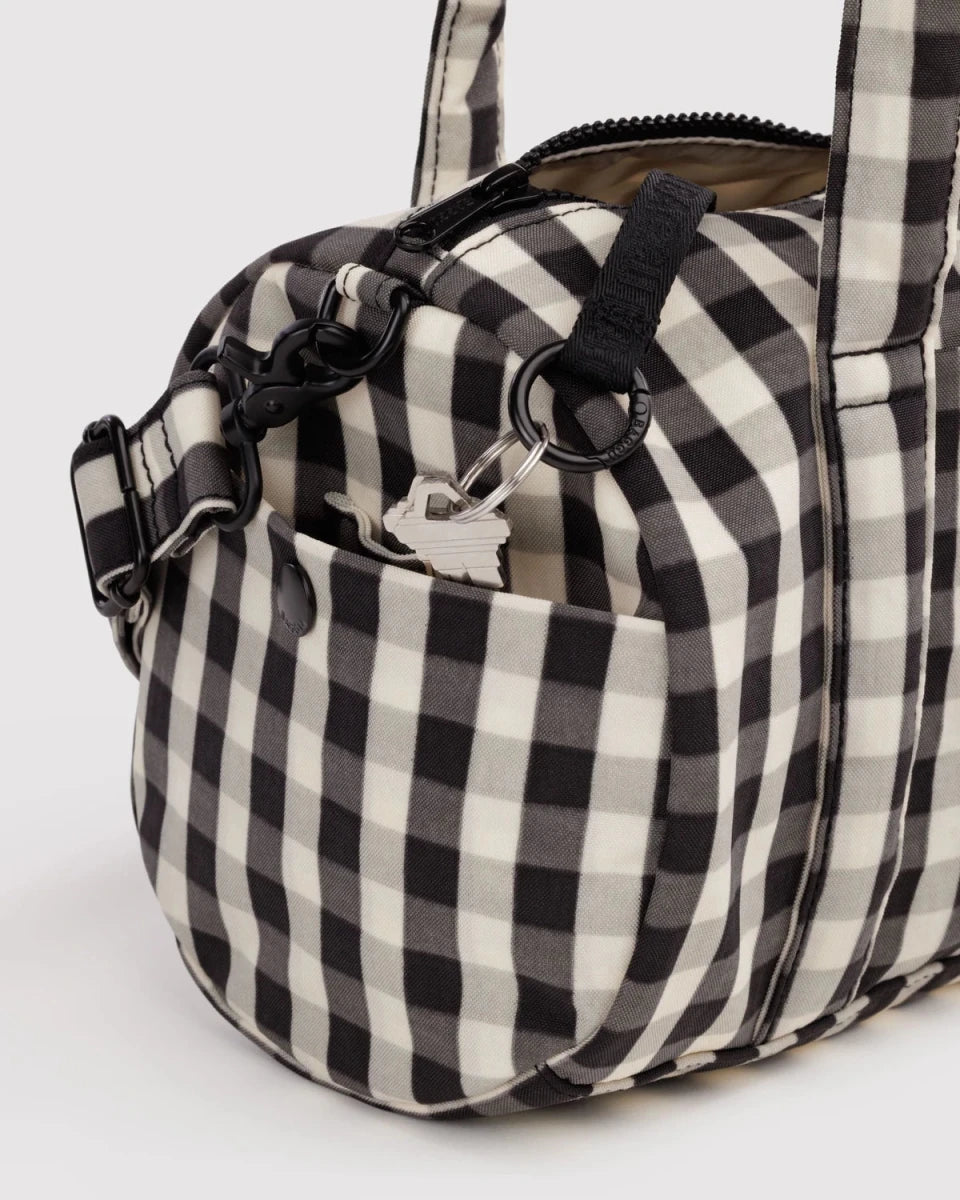 Black and cream gingham nylon duffle bag by Baggu, featuring a spacious design and sturdy shoulder strap for travel and gym use.