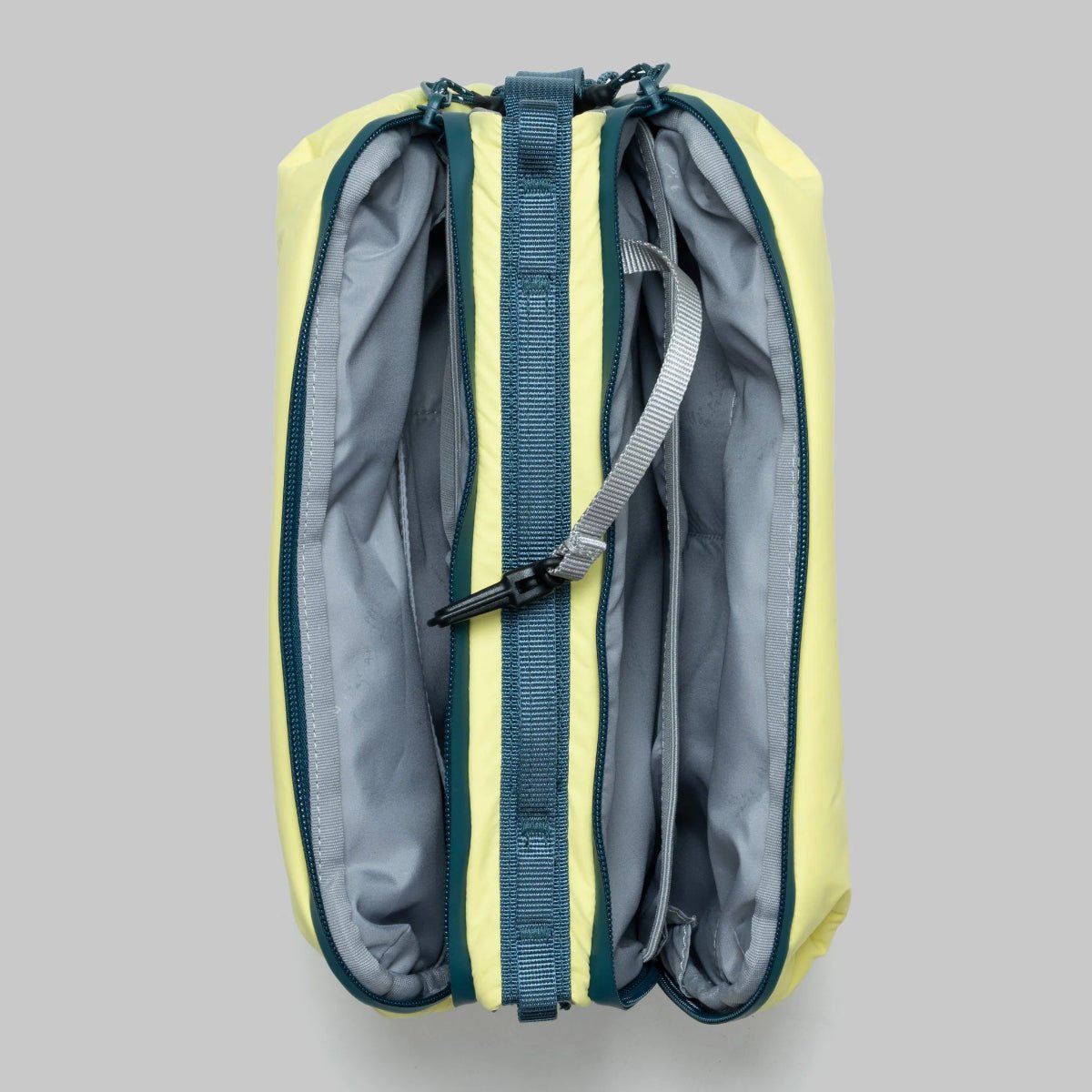 Large puffy canary yellow bottle bag from topologie with zips open shot from above on a gray background