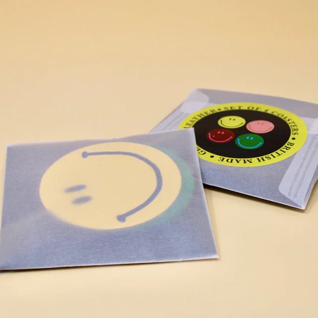 Set of four Happy Face Smilie leather coasters by Ark Colour Design, featuring cheerful smiley face designs on smooth leather surfaces.