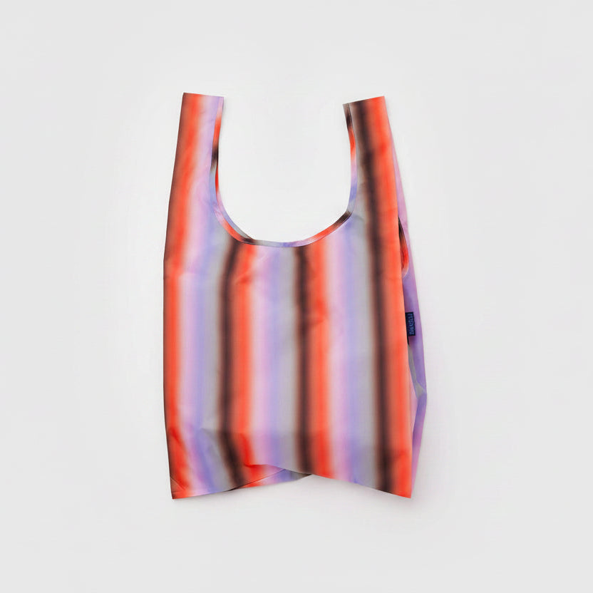 Baggu bag featuring a gradient stripe design in poppy and lilac colors, showcasing a lightweight, stylish fabric tote bag.
