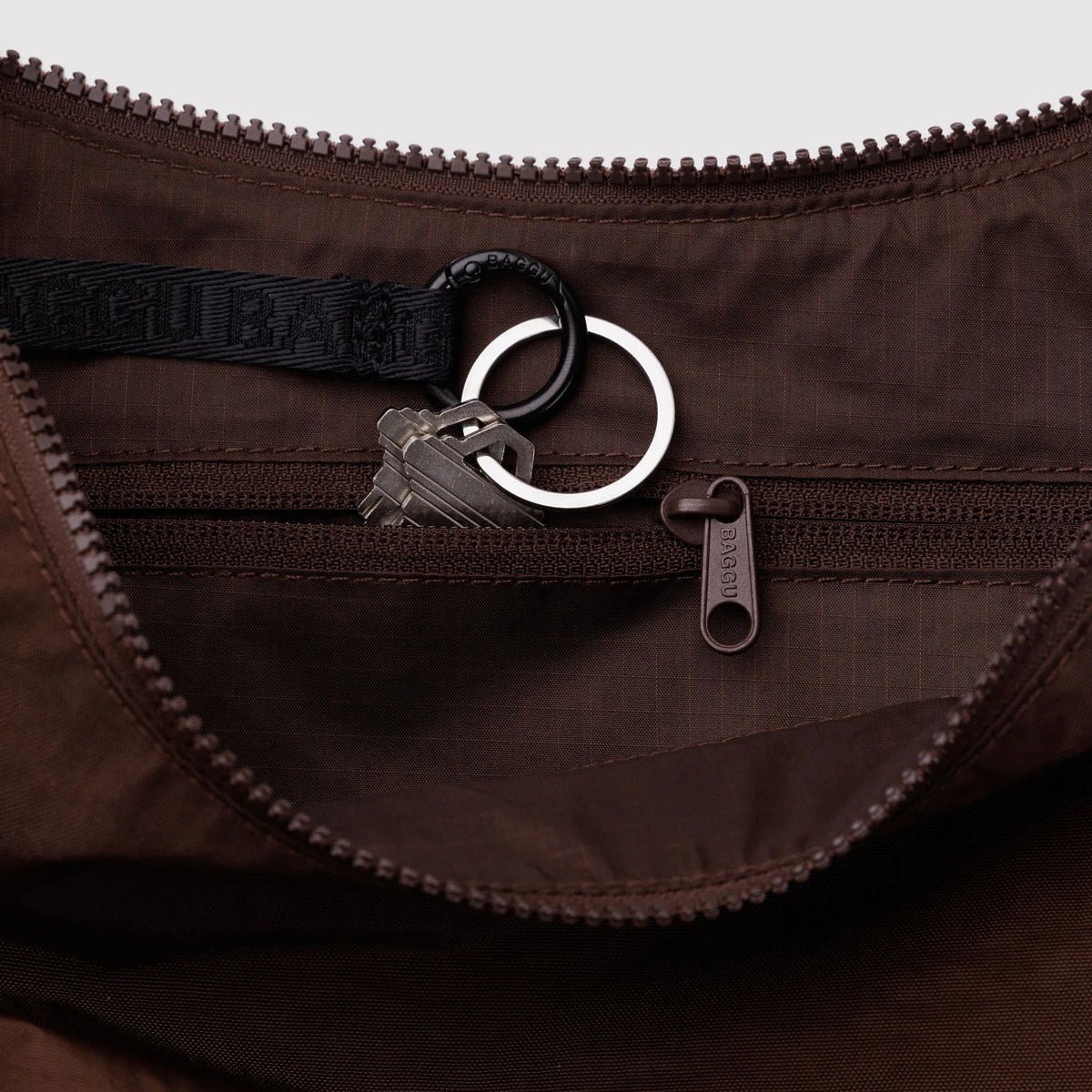 Baggu Crescent Shoulder Bag in neutral fabric with adjustable strap, stylish and functional accessory for everyday use.
