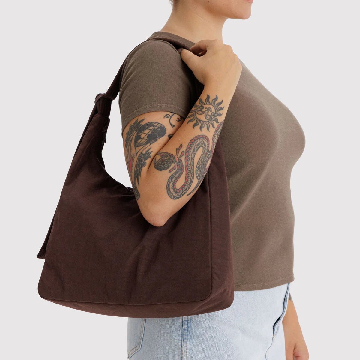 Person holding a brown bag with a plain background