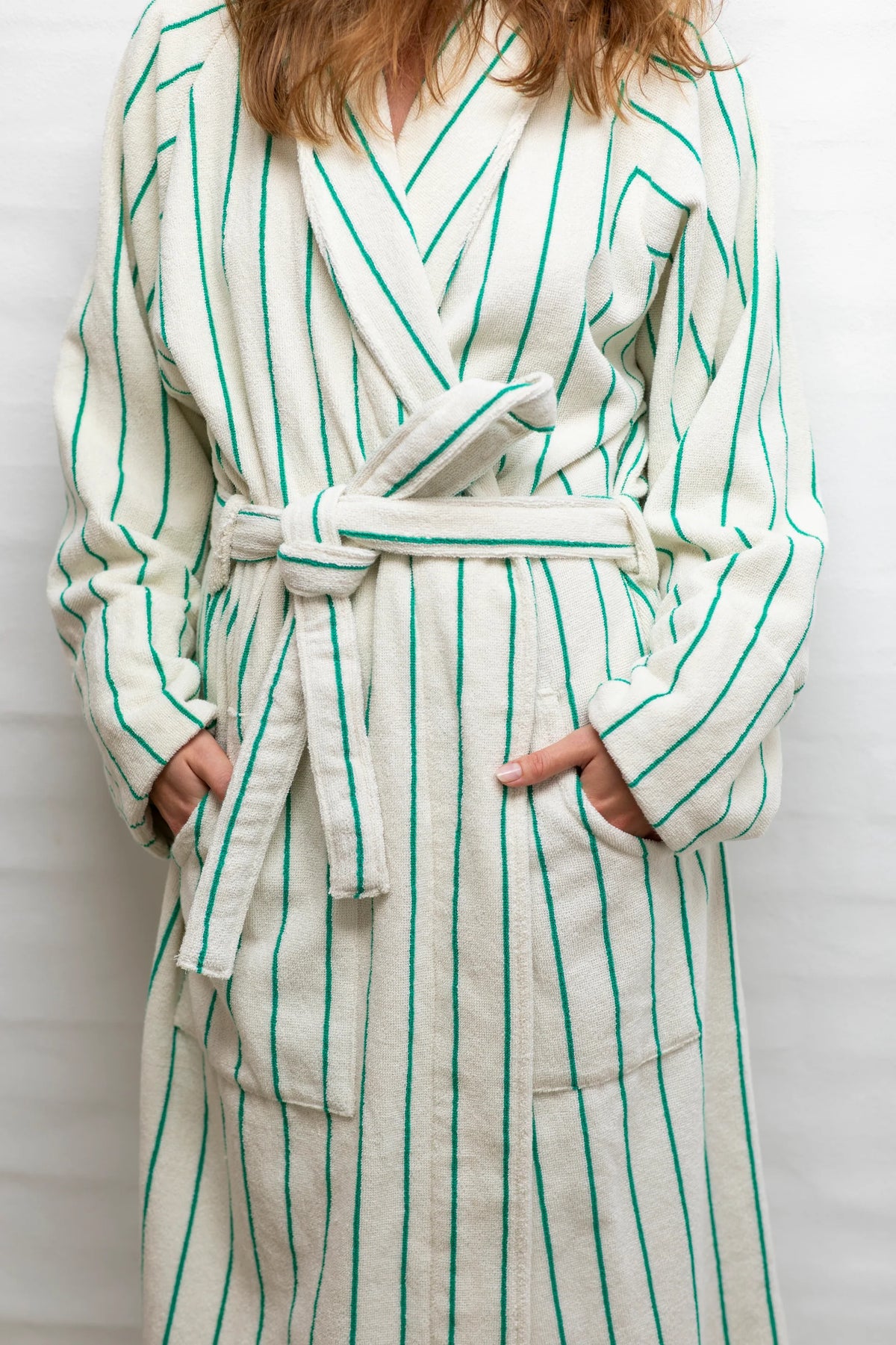 Bongusta Naram white and grass bathrobe for bathroom, S/M size, soft and plush fabric, hanging on a hook.