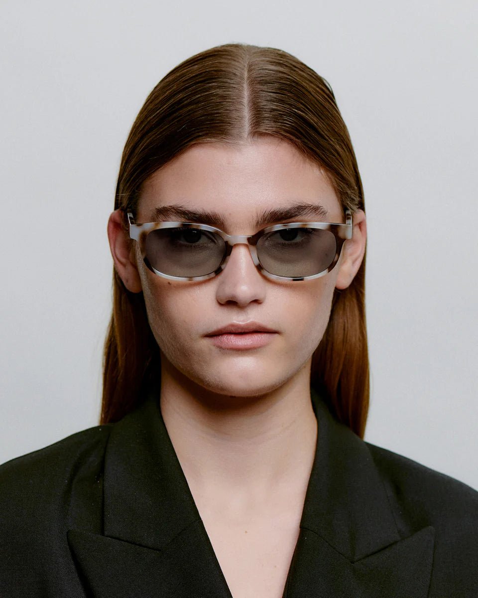 A. Kjaerbede Charlie sunglasses with cookie-dough-colored frames and dark tinted lenses, stylish and modern eyewear.