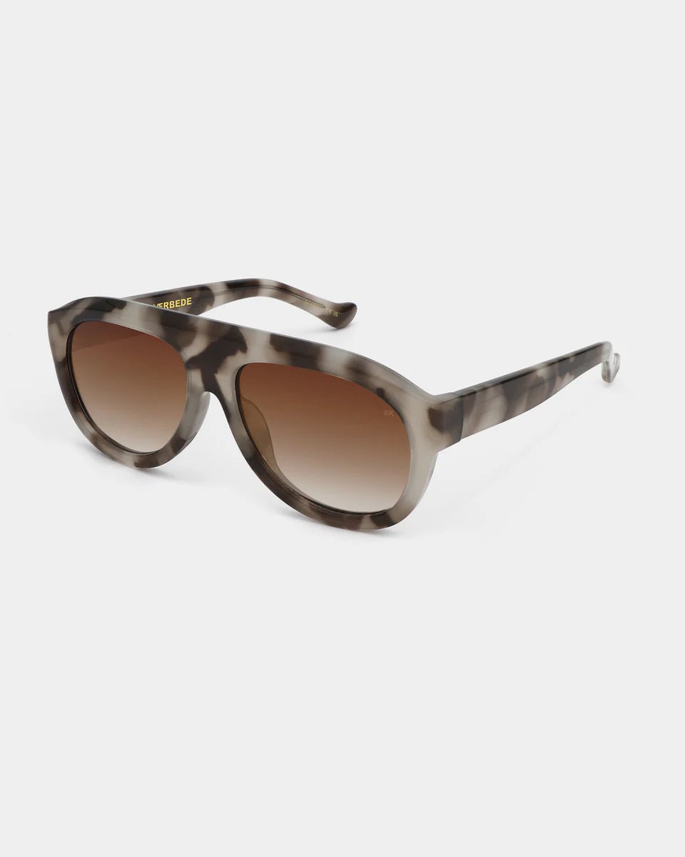 A. Kjaerbede Rio sunglasses with cookie dough-colored frames and dark tinted lenses, stylish and trendy eyewear.