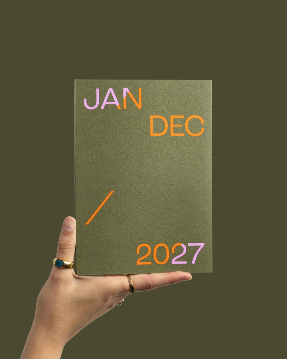 Dusty pink 2027 mishmash planner with time-block layout open to weekly pages, showing organized daily sections and date headers.