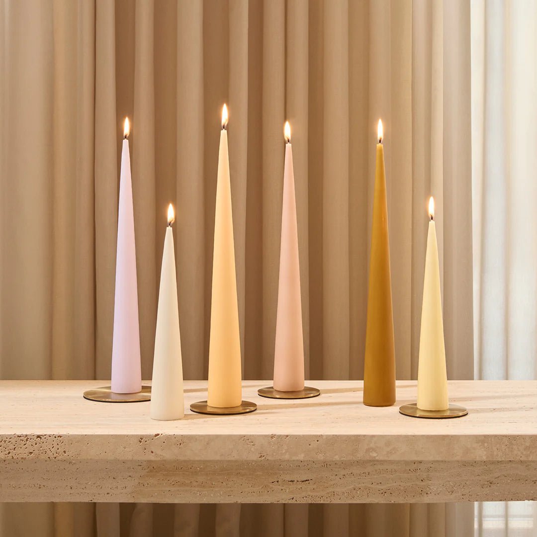 Set of white cone candles by Ester & Erik, displayed on a wooden surface, showcasing their elegant, minimalist design.