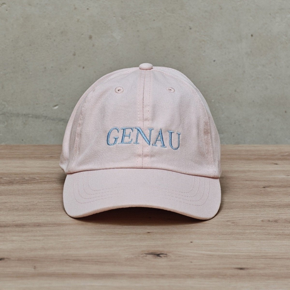 Embroidered Hallesches Haus 'GENAU' cap with adjustable strap, featuring detailed stitching and classic baseball cap style.