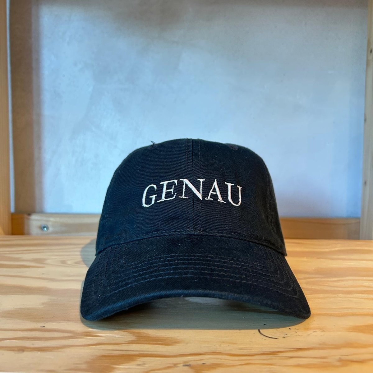 Embroidered 'GENAU' cap by Hallesches Haus featuring a classic design and adjustable strap, shown from front view.