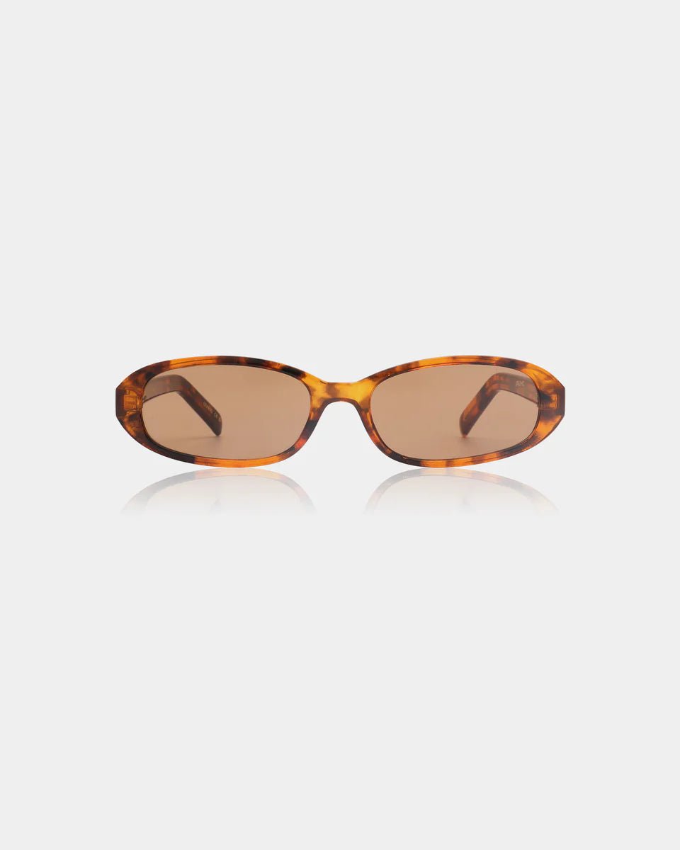 A. Kjaerbede Havana Macy sunglasses with round frames and brown tortoiseshell pattern, resting on a white surface.