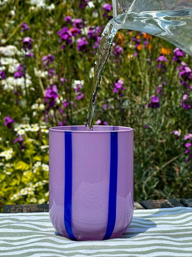 MÆGEN Atina glassware set featuring lilac and navy glass pieces with elegant, modern design on clear glass background.