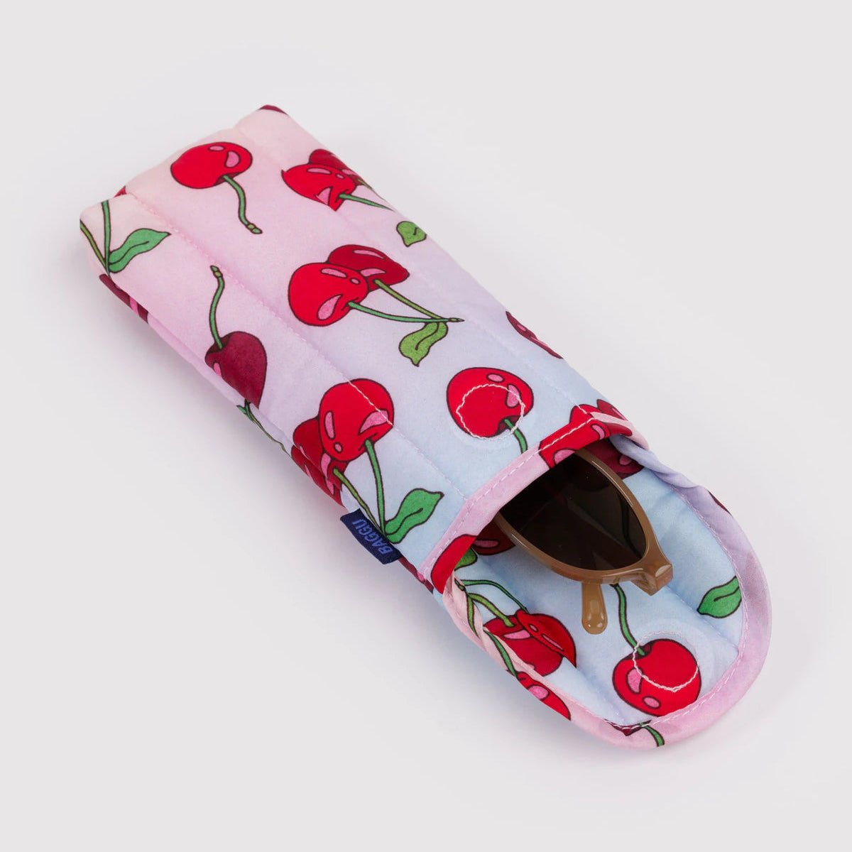 puffy glasses case with cherry pattern open with brown sunglasses poking out on a white background