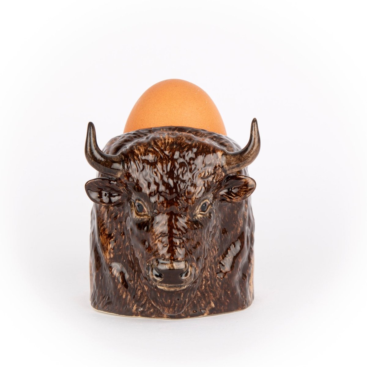 Bull-shaped egg holder with an egg on a white background