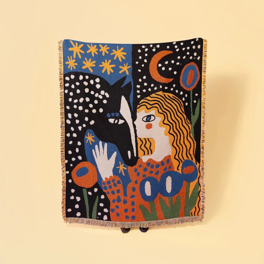 Colorful blanket with artistic design of a woman and a wolf on a beige background