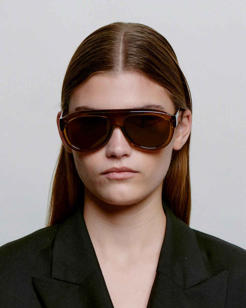 Smoke-transparent Rio sunglasses by A. Kjaerbede with round frames and tinted lenses, stylishly displayed against a neutral background.