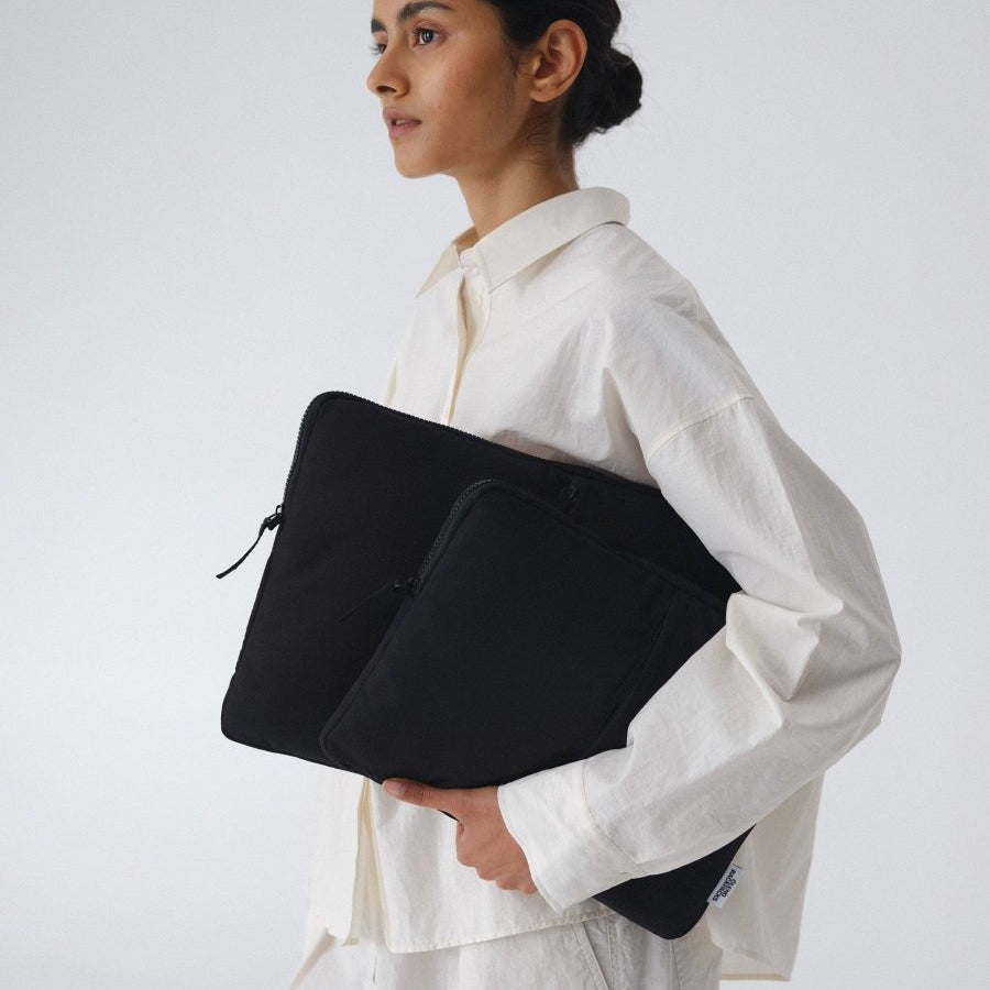 Black Ölend Backpacks padded laptop sleeve for 13-inch and 14-inch laptops, shown with a snug fit and soft interior.