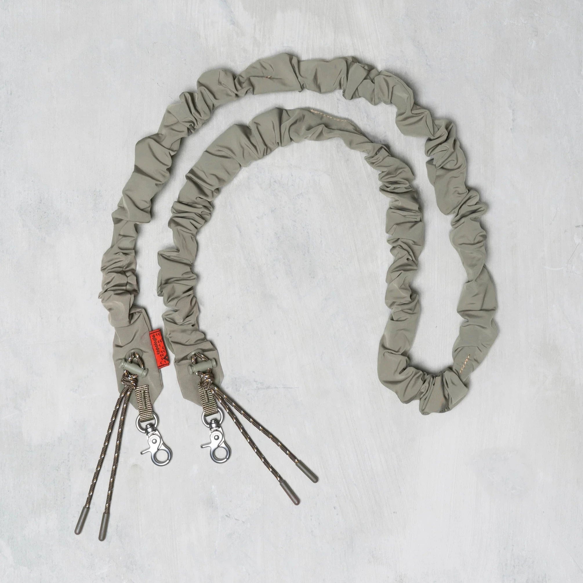 Topologie Bungee Strap for Bags, black elastic cord with metal hooks, designed for secure attachment and stylish look.