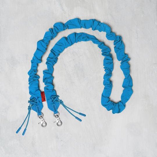 Topologie Bungee Strap for Bags, adjustable black elastic strap with metal hooks for secure attachment and versatile use.