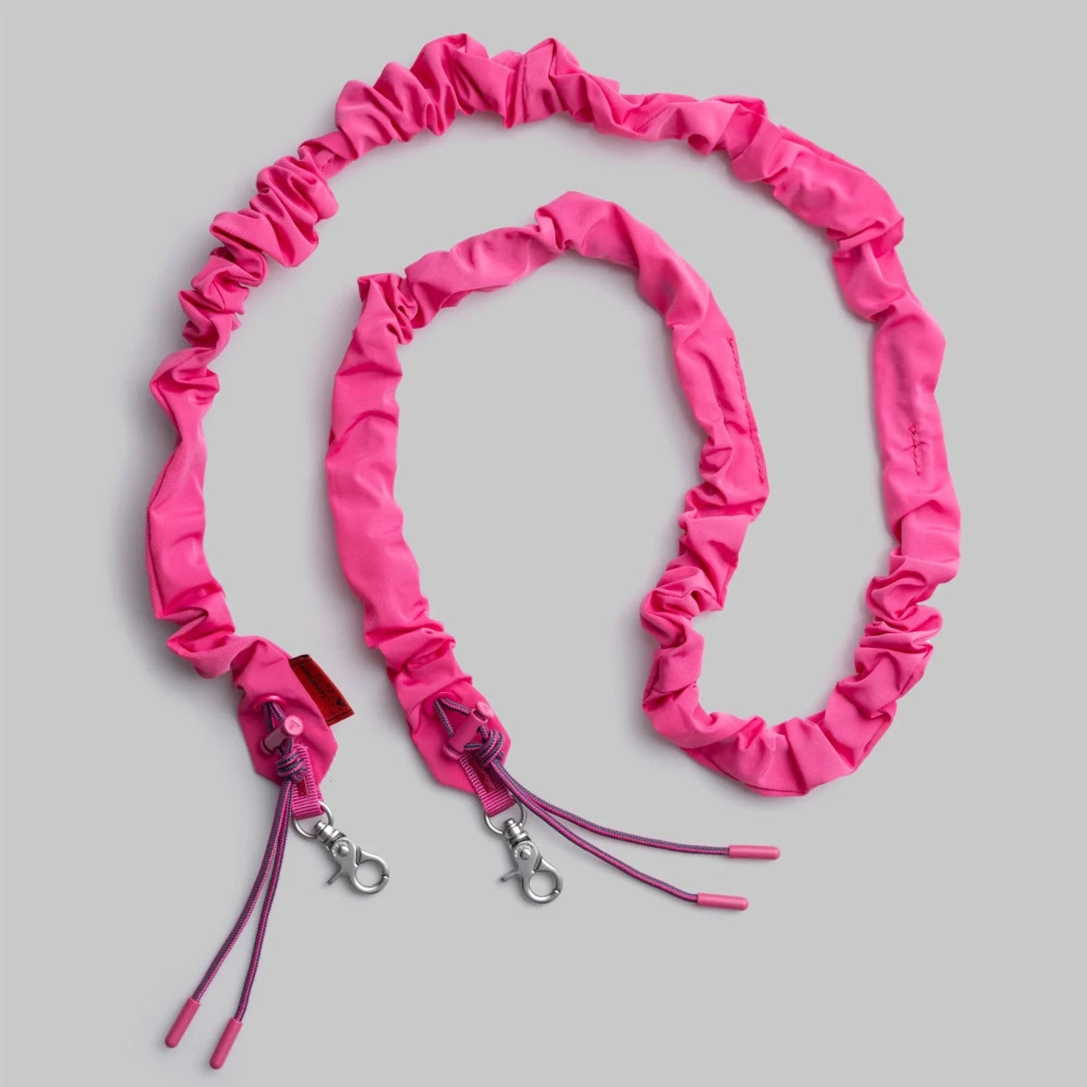 Topologie Bungee Strap attached to a bag, showing adjustable elastic cord for securing items or added style on the Topologie bag.