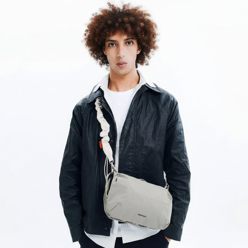 Large Topologie Bottle Sacoche bag in black with adjustable strap, designed for carrying water bottles and essentials.