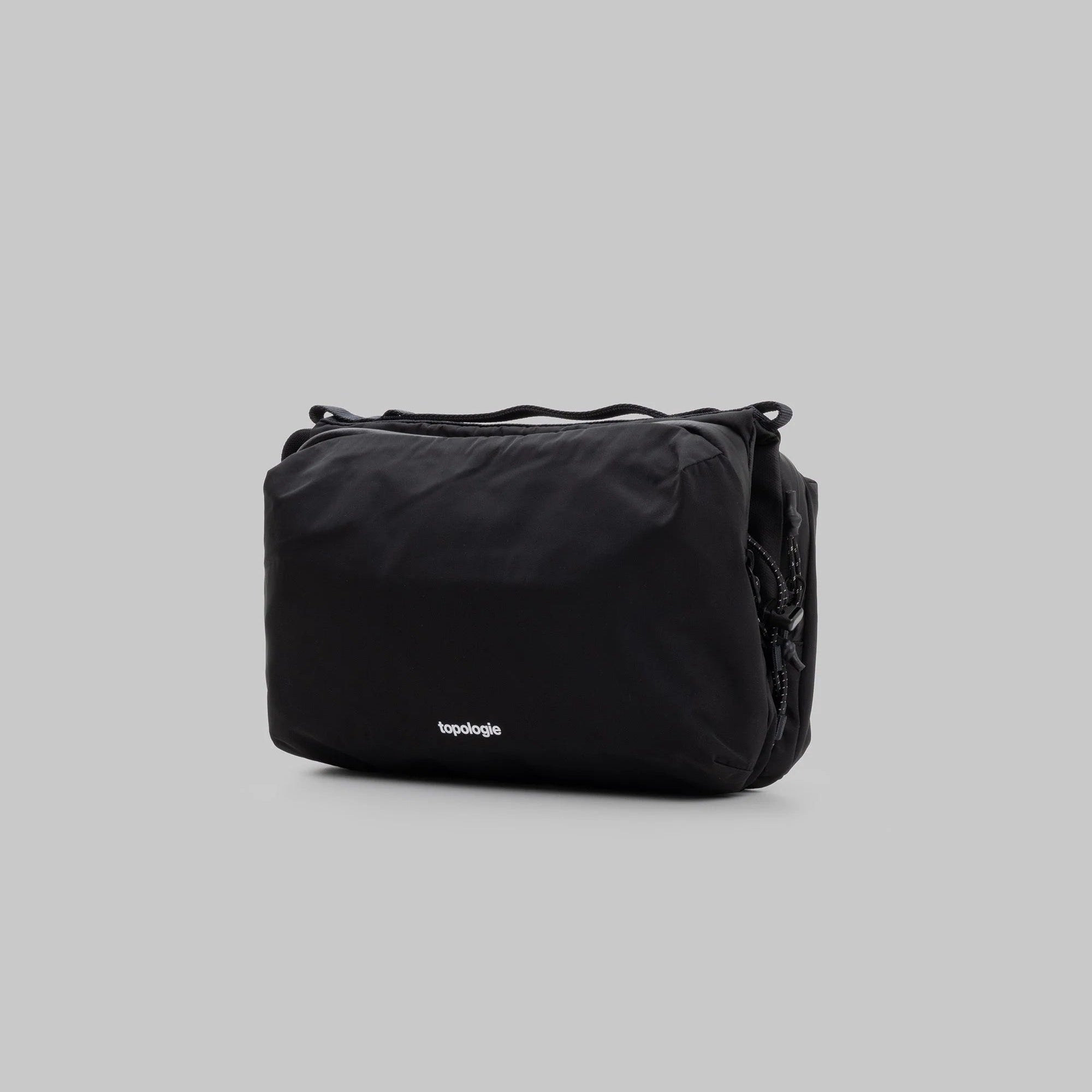 Large Topologie Bottle Sacoche bag with adjustable strap, made of durable material, designed for convenient carrying.