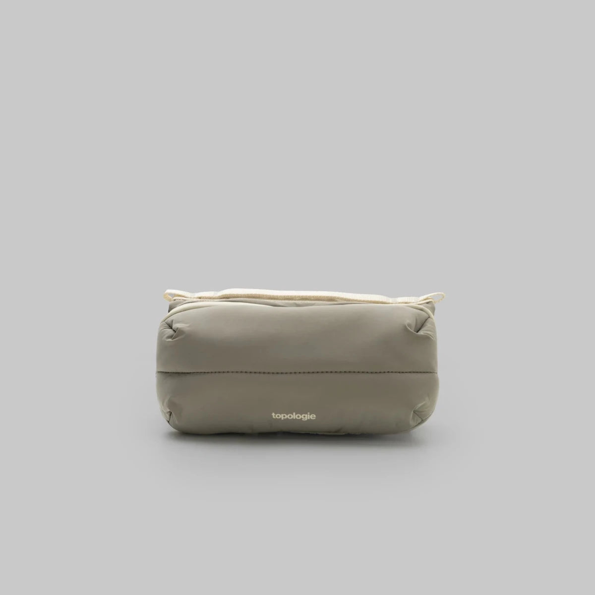Beige puffy bottle bag with 'topologie' branding on a gray background