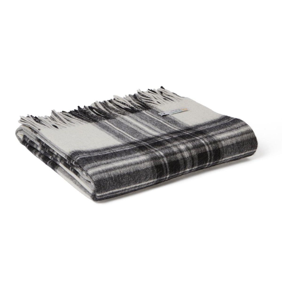 Cream Tweedmill Lambswool Wool Blanket draped over a cozy armchair, showcasing soft, high-quality wool texture.