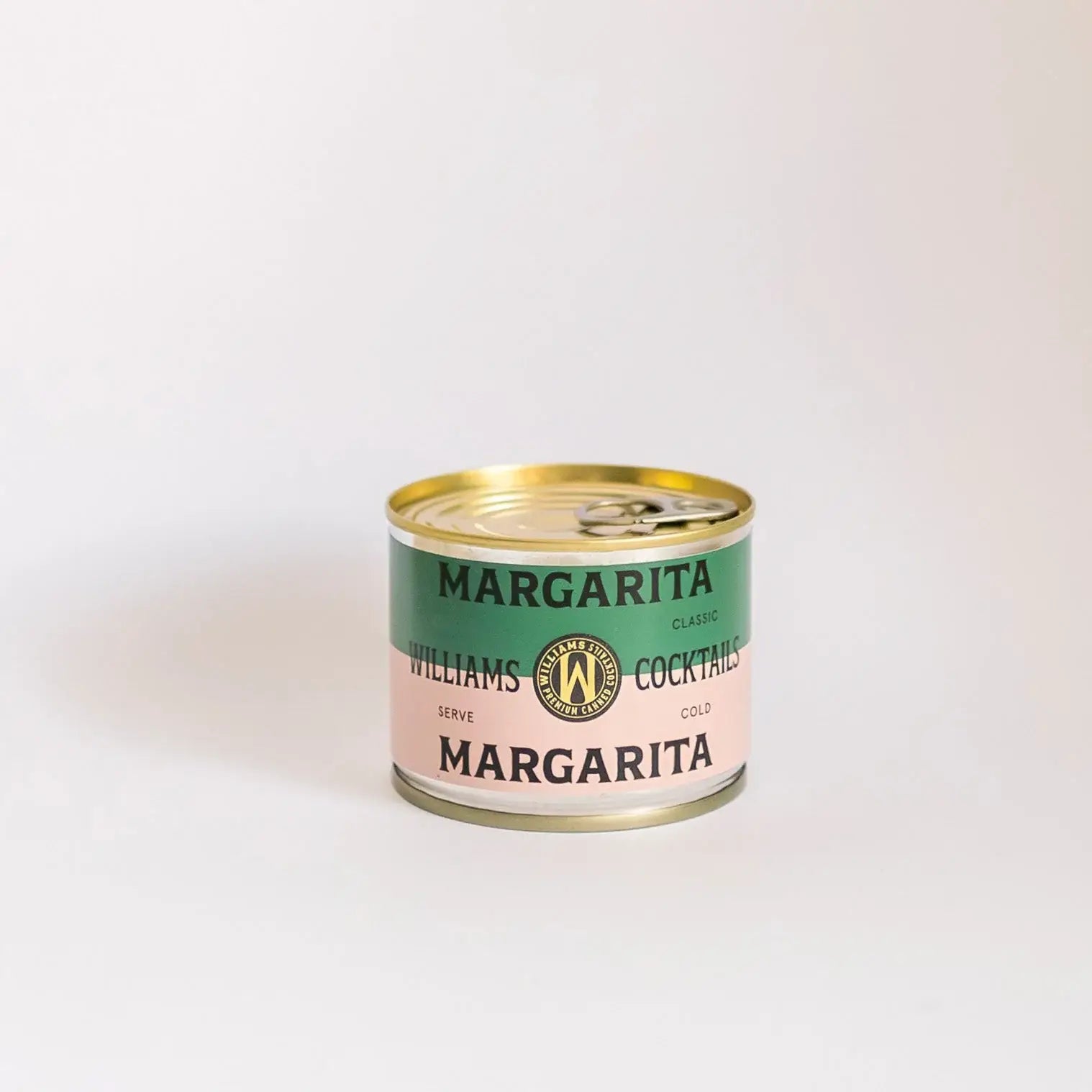 Williams Premium Canned Cocktails Margarita featuring a clear glass filled with a vibrant lime and salted rim on a table.