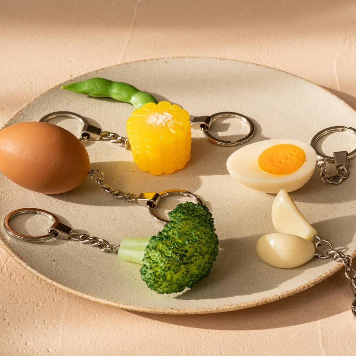 Hard-boiled egg-shaped keychain accessory by Yumazing, featuring a realistic design and vibrant colors.