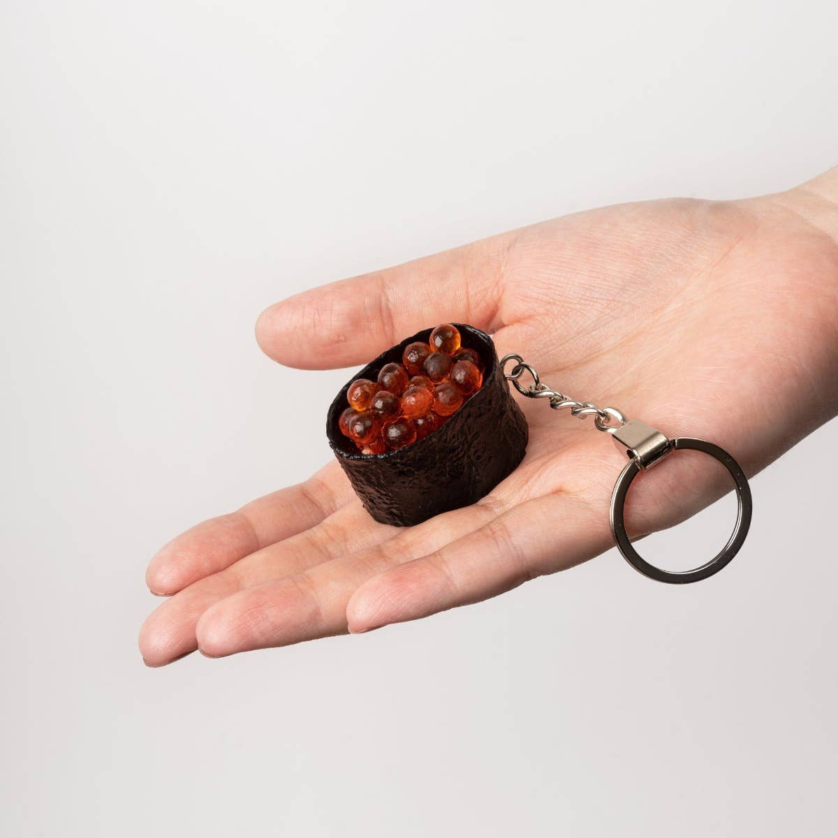 Yumazing Connectrade AG keychain featuring a detailed Ikura Sushi design with orange salmon roe and realistic rice appearance.
