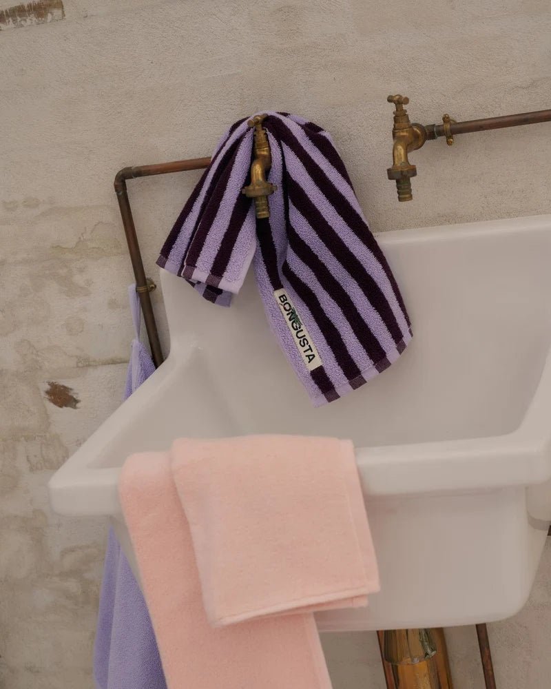 Soft blush-colored Naram Bathroom Towel by Bongusta folded on a bathroom rack, showcasing plush texture and elegant design.