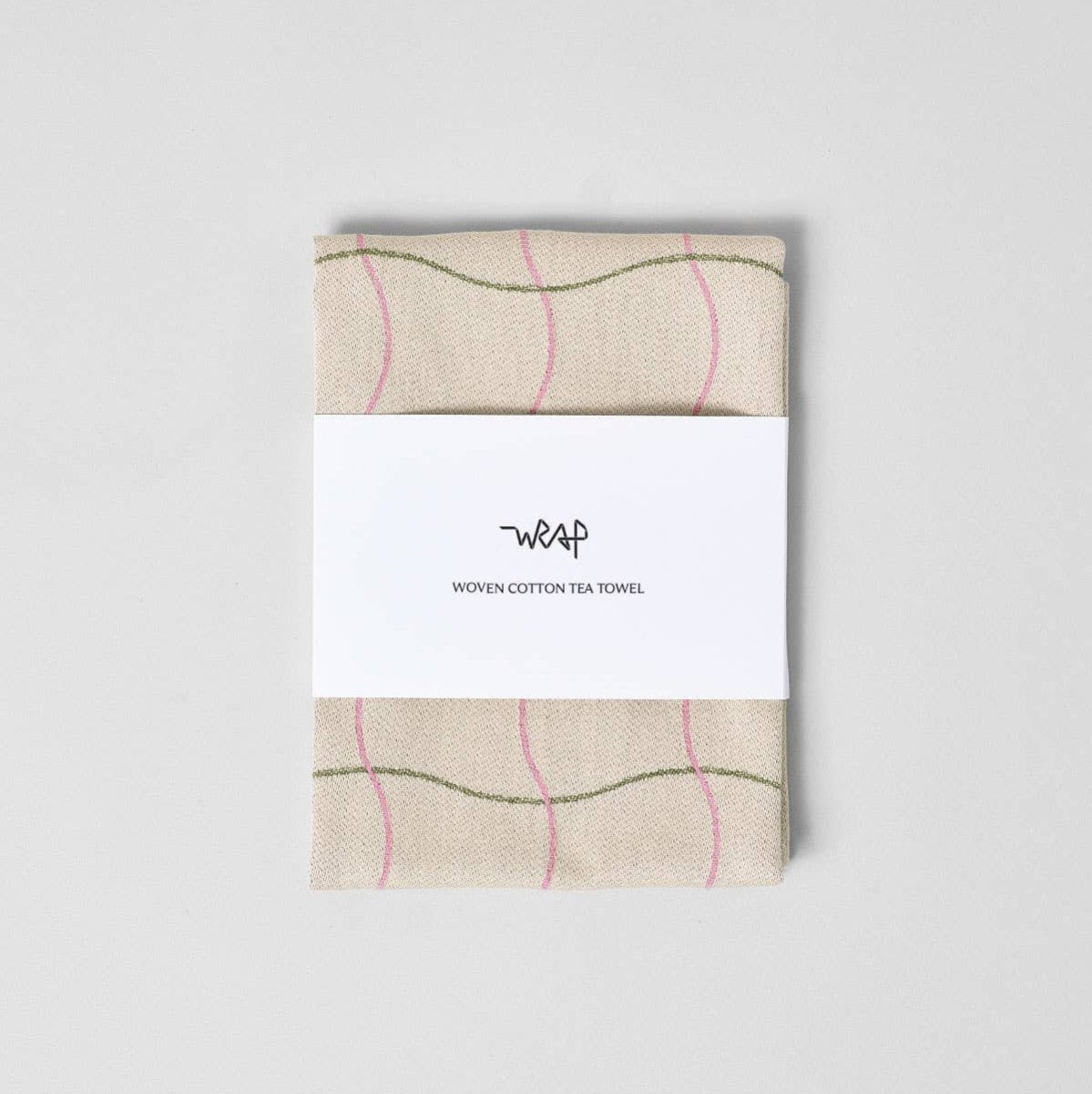 Woven cotton tea towel with a white label on a light gray background