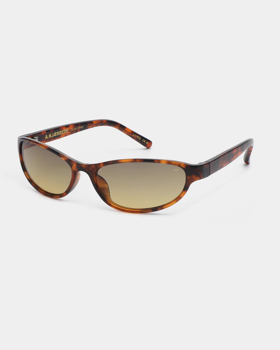 A. Kjaerbede Alexa sunglasses with havana-colored frames and dark lenses, shown from a side angle on a white background.