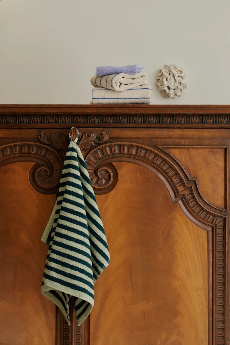 Sea foam and deep teal Naram bathroom towel by Bongusta, showing soft, plush fabric with textured pattern in a bathroom setting.