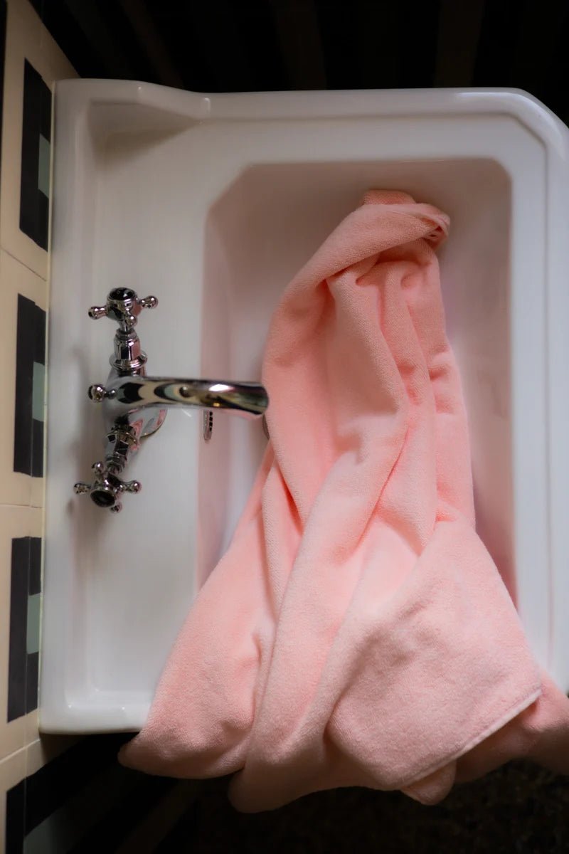 Soft blush-colored bathroom towel from Bongusta Naram Towel collection, neatly folded on a clean surface.