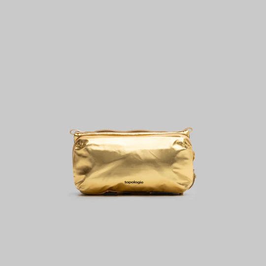 Gold pouch with brand name on a gray background