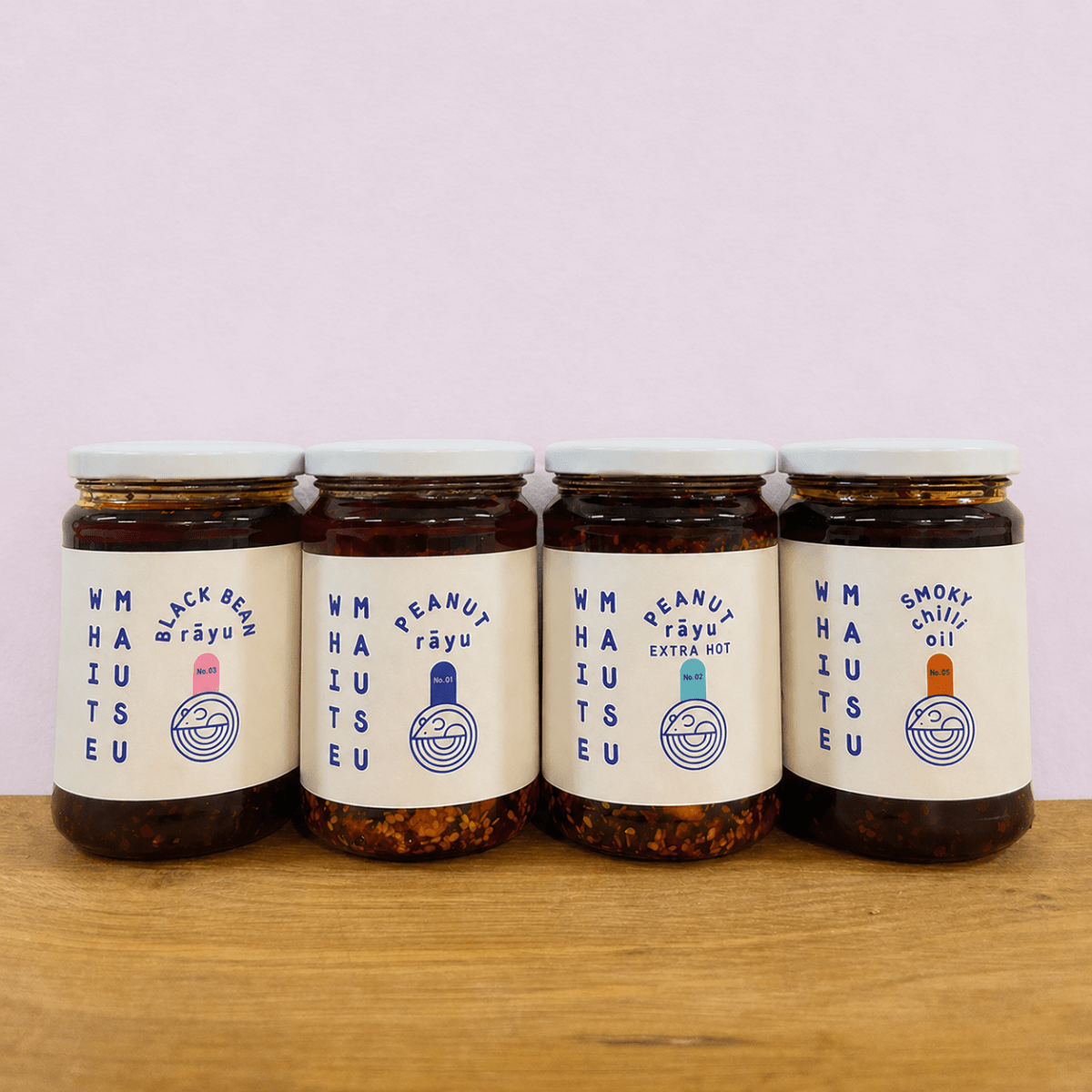 Bottle of smoky chili oil by White Mausu Ltd, featuring rich, dark oil with red chili peppers and a textured label.