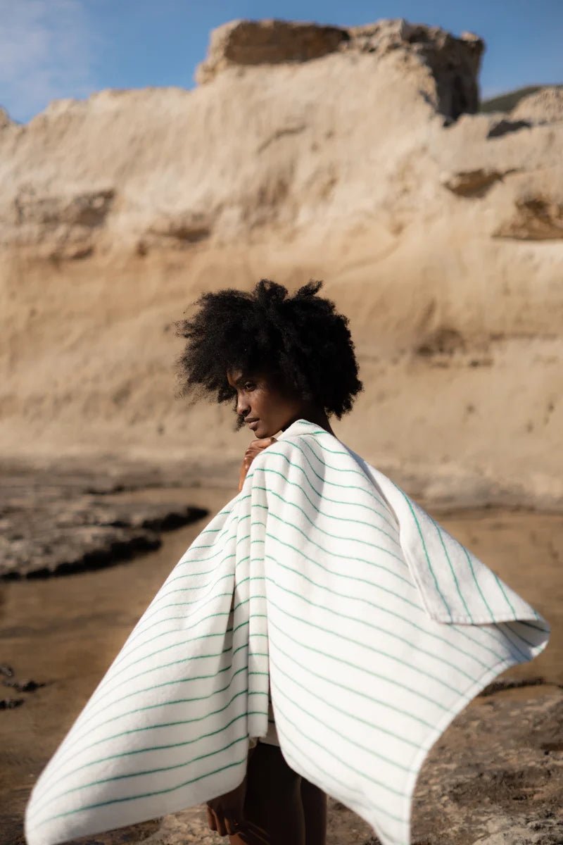 Bongusta Naram Towel in pure white and grass green, soft cotton bathroom towel displayed in desert setting