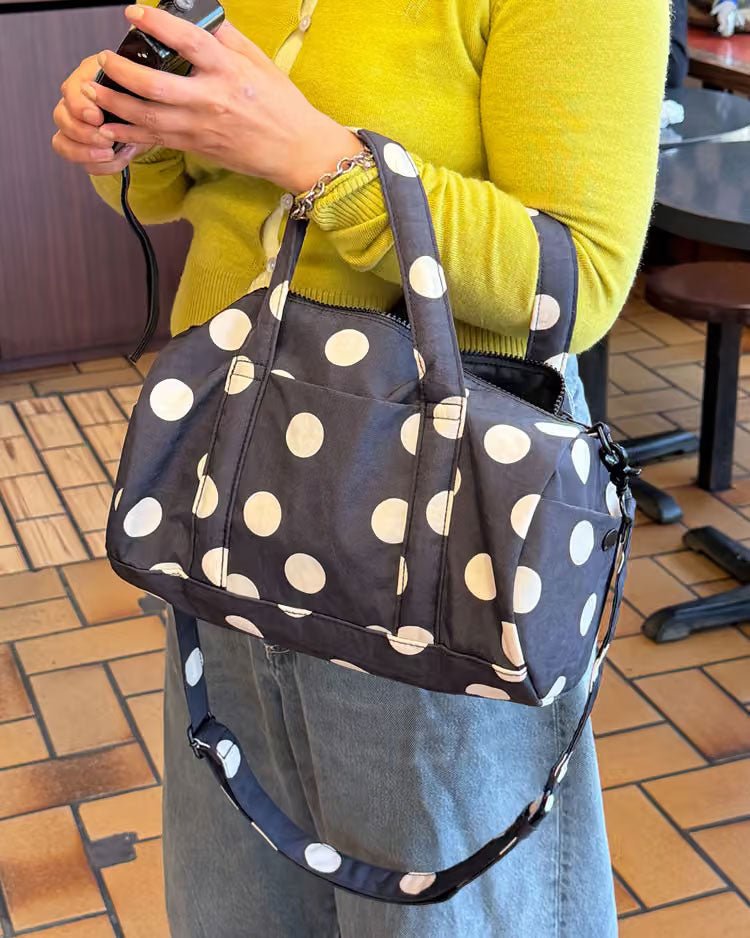 Black and cream polka dot Nylon Duffle Bag by Baggu, showing a stylish, lightweight travel and gym bag with sturdy handles.