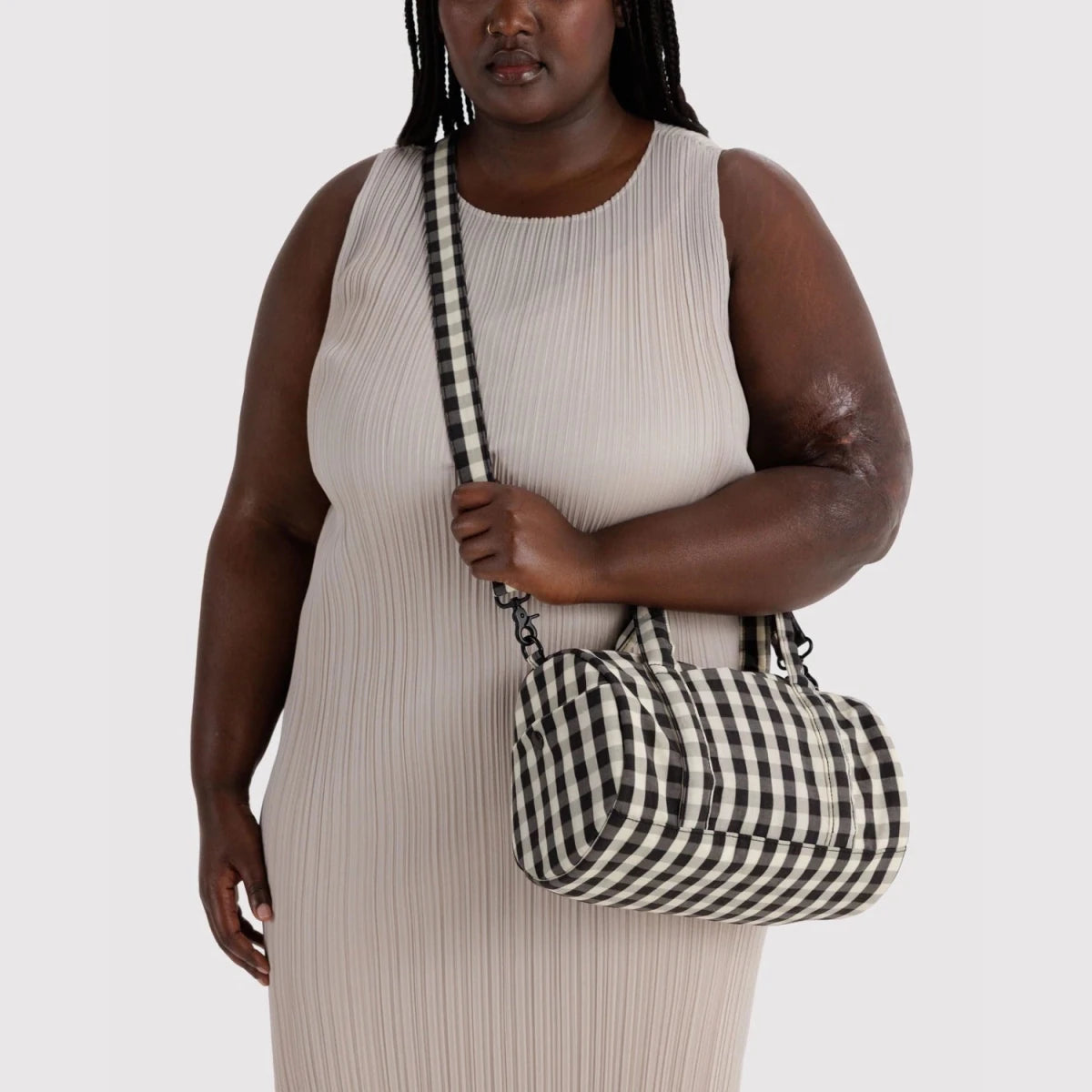 Black and cream gingham nylon duffle bag by Baggu with sturdy handles and spacious main compartment.