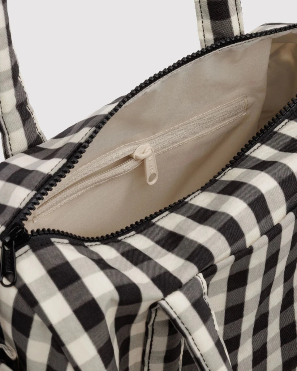 Baggu nylon duffle bag in black and cream gingham pattern, showcasing its spacious design and sturdy handles.