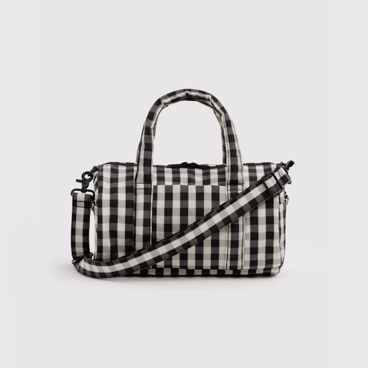 Black and cream gingham nylon duffle bag by Baggu, spacious travel bag with sturdy handles and zipper closure.