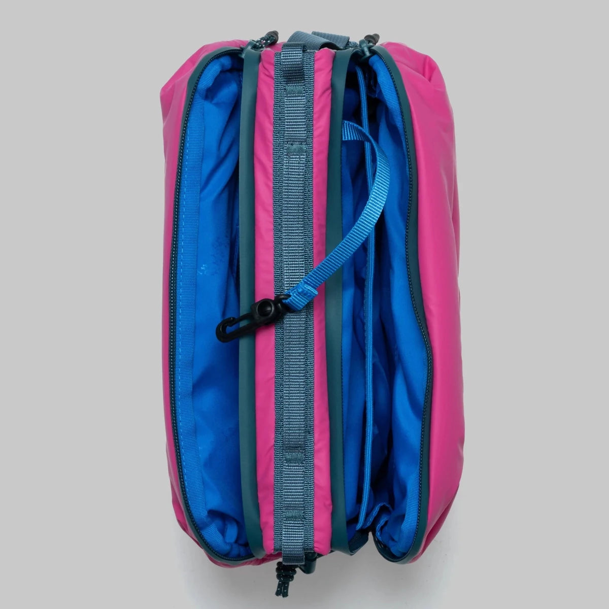 Large pink puffy bottle bag from topologie shot from above with zips open on a grey background