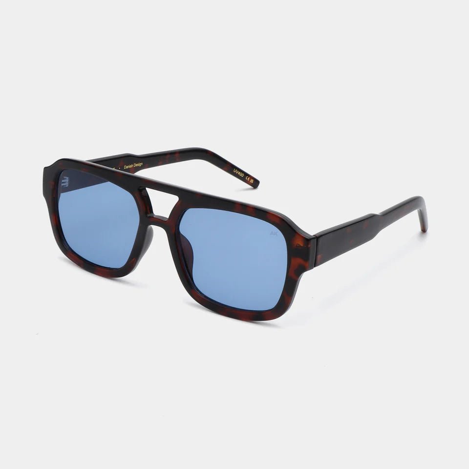 A. Kjaerbede Kaya sunglasses with rounded frames and tinted lenses, stylishly displayed against a neutral background.
