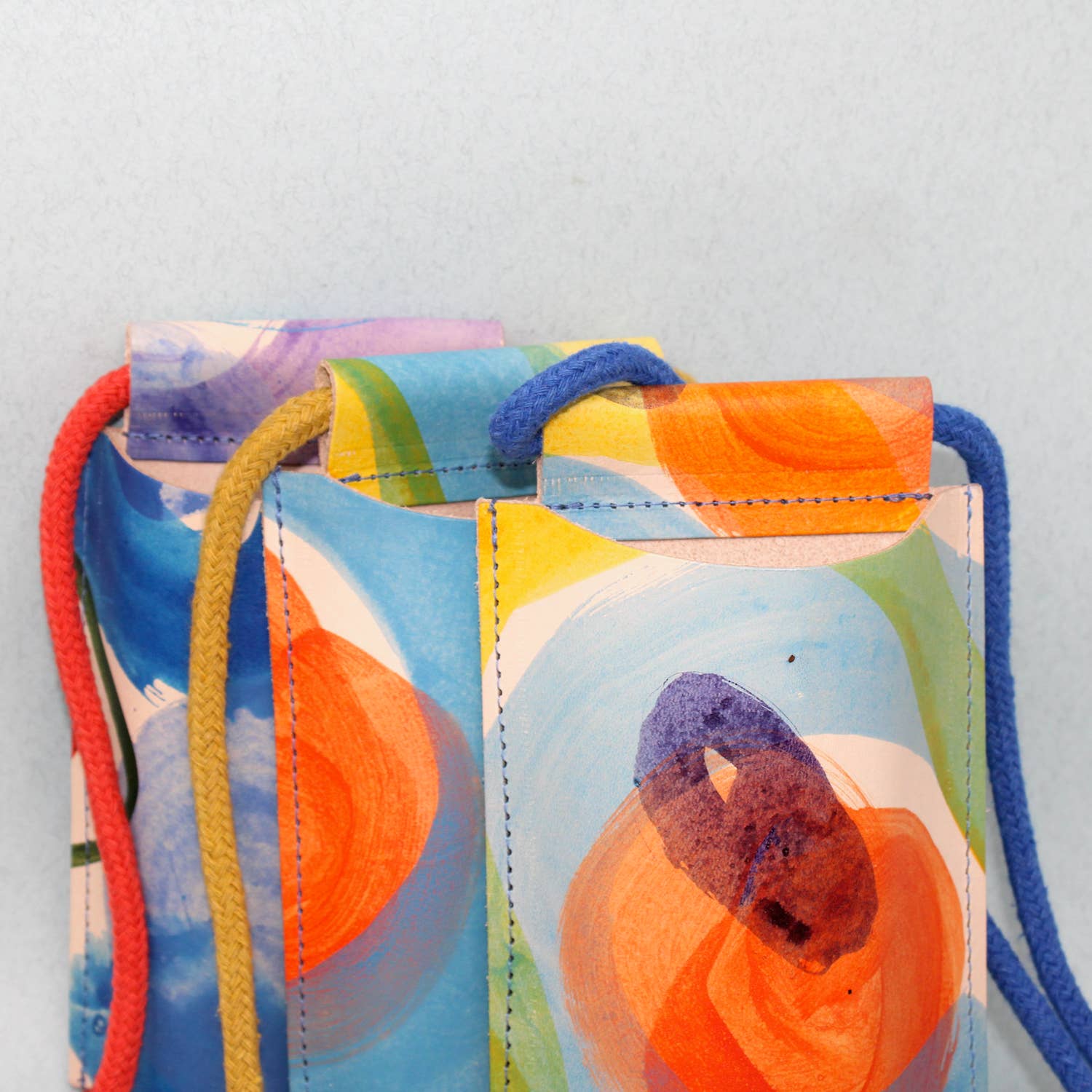 Hand-painted leather phone bag by Ark Colour Design featuring colorful artistic design and compact, stylish carryall.