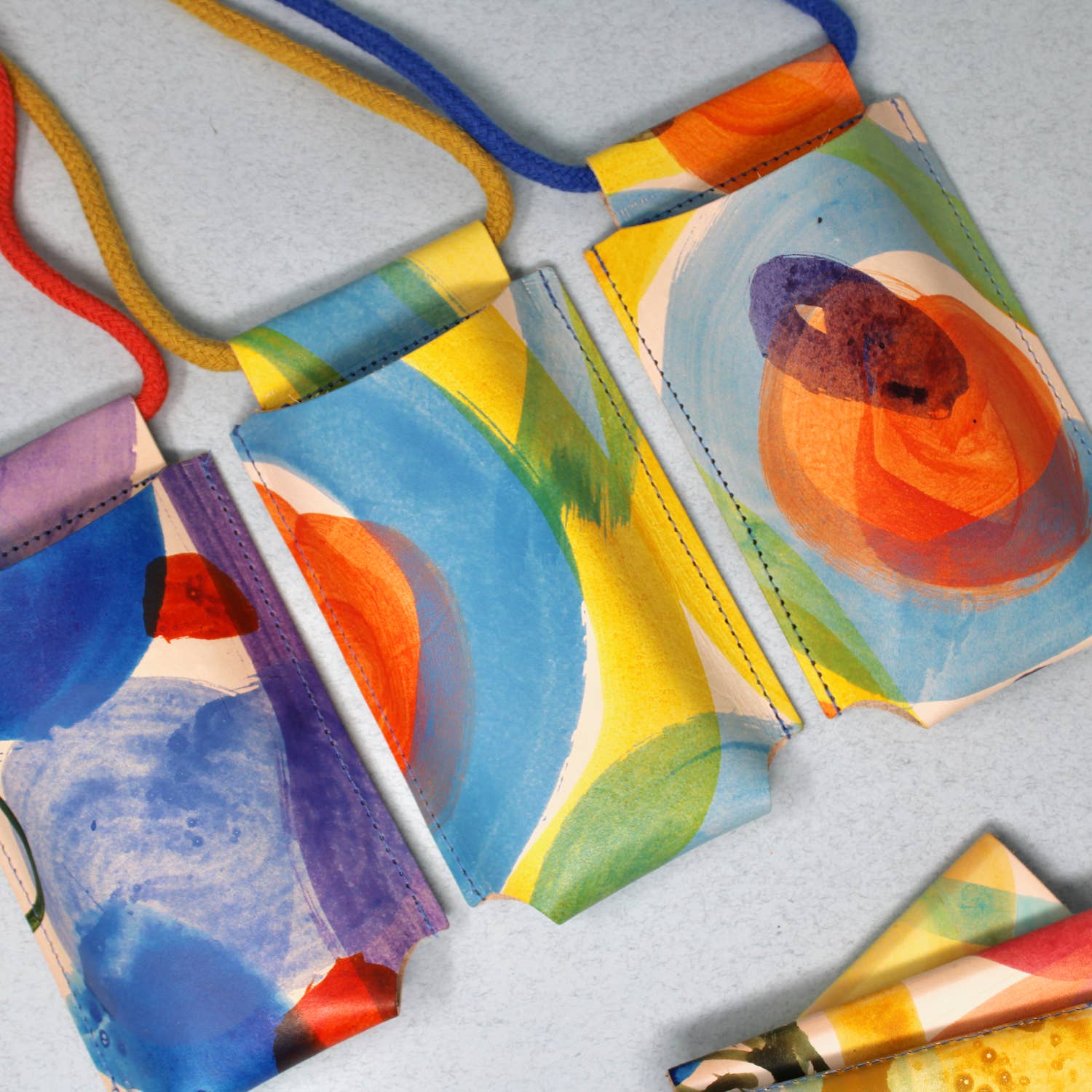 Hand-painted leather phone bag by Ark Colour Design featuring artistic floral patterns and a compact, stylish design.